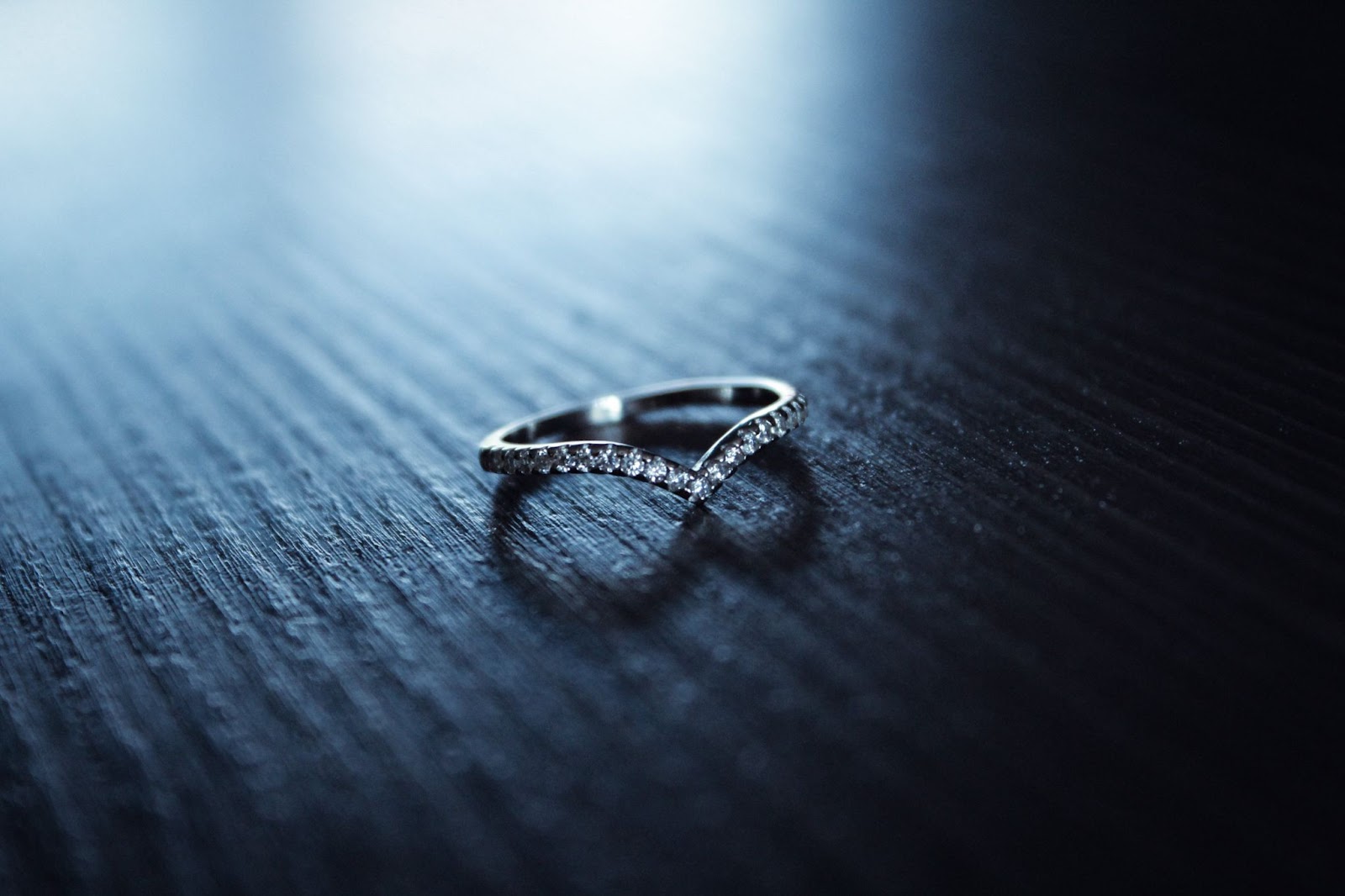 A wedding band covered in diamonds that has a V indent to set better against the center stone of an engagement ring